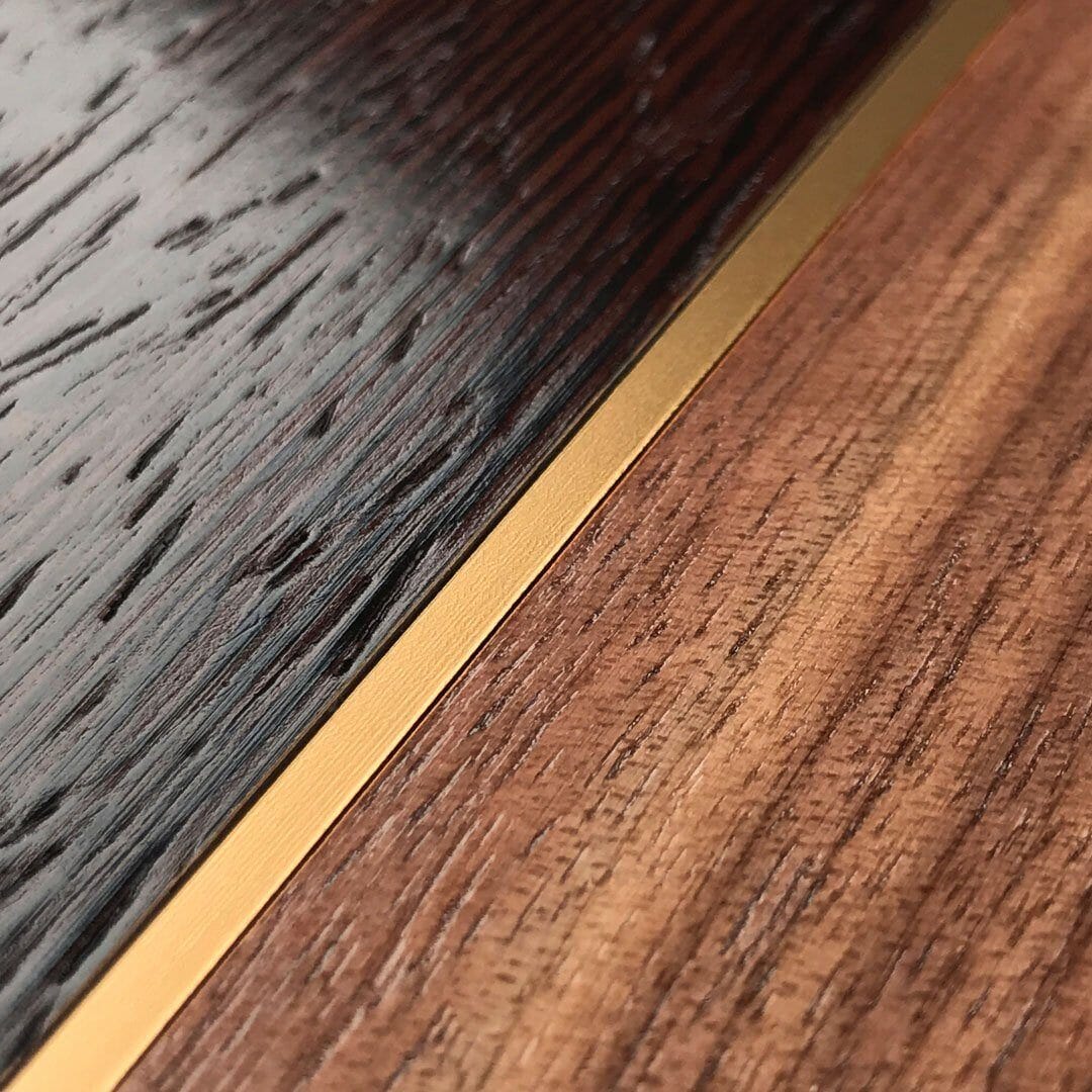 Zoomed in detailed shot of the Alium wood phone case featuring Wenge, Walnut and a Gold Metallic divider