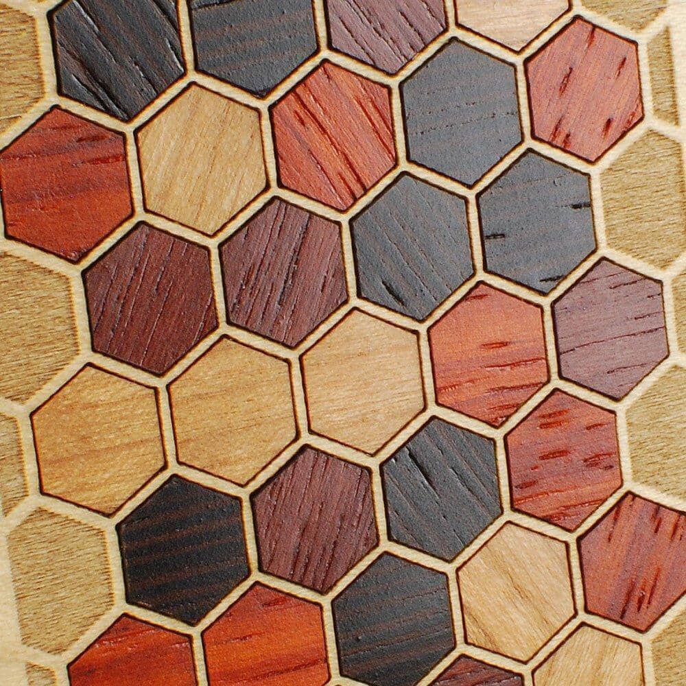 Zoomed in detailed shot of the Cellular wood phone case featuring hexagon shapes of laser cut Cherry, Sapele, Padauk, and Wenge on an engraved Maple backer by Keyway