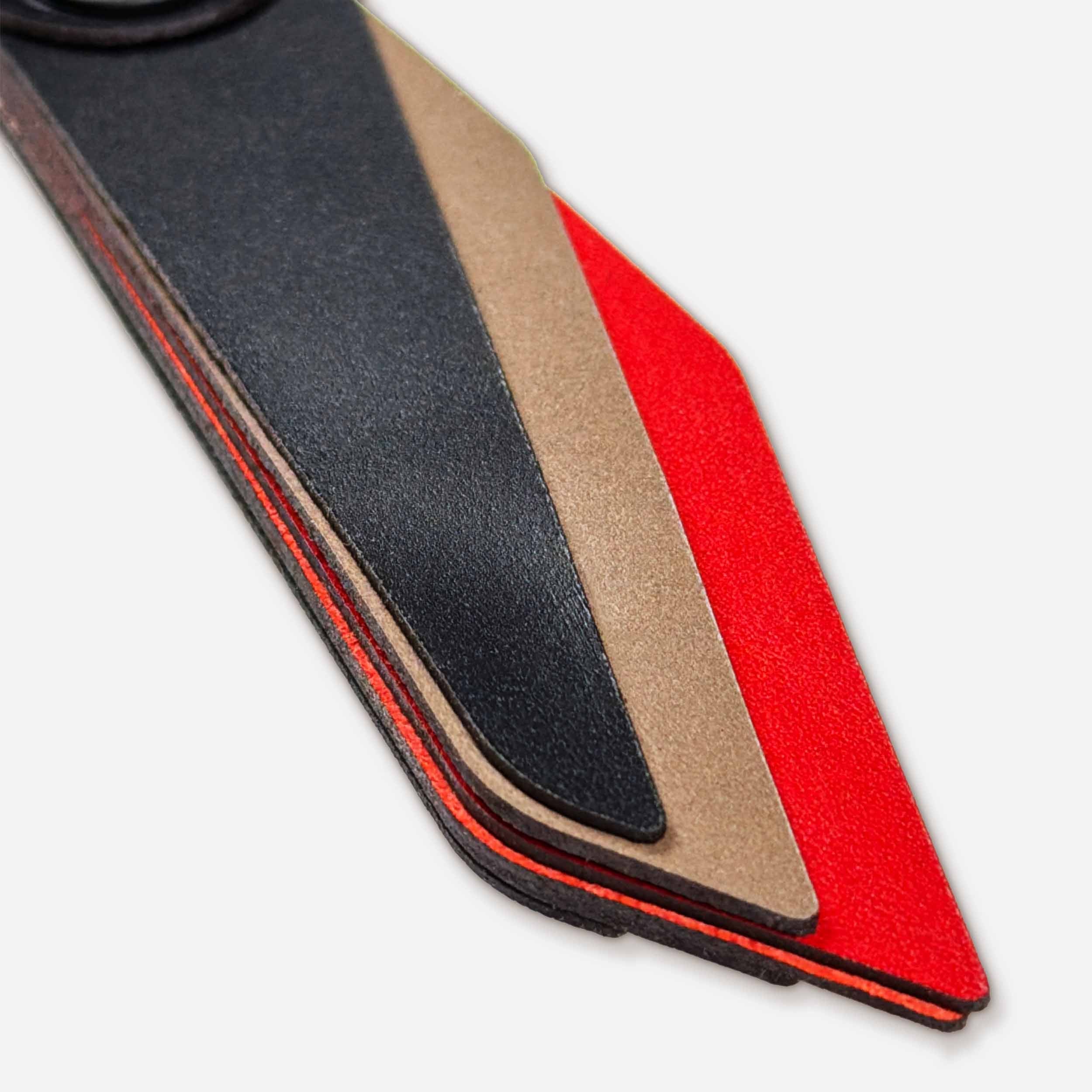 Close-up of Flint leather keychain showing layered Italian full-grain veg-tan in black, taupe, and red