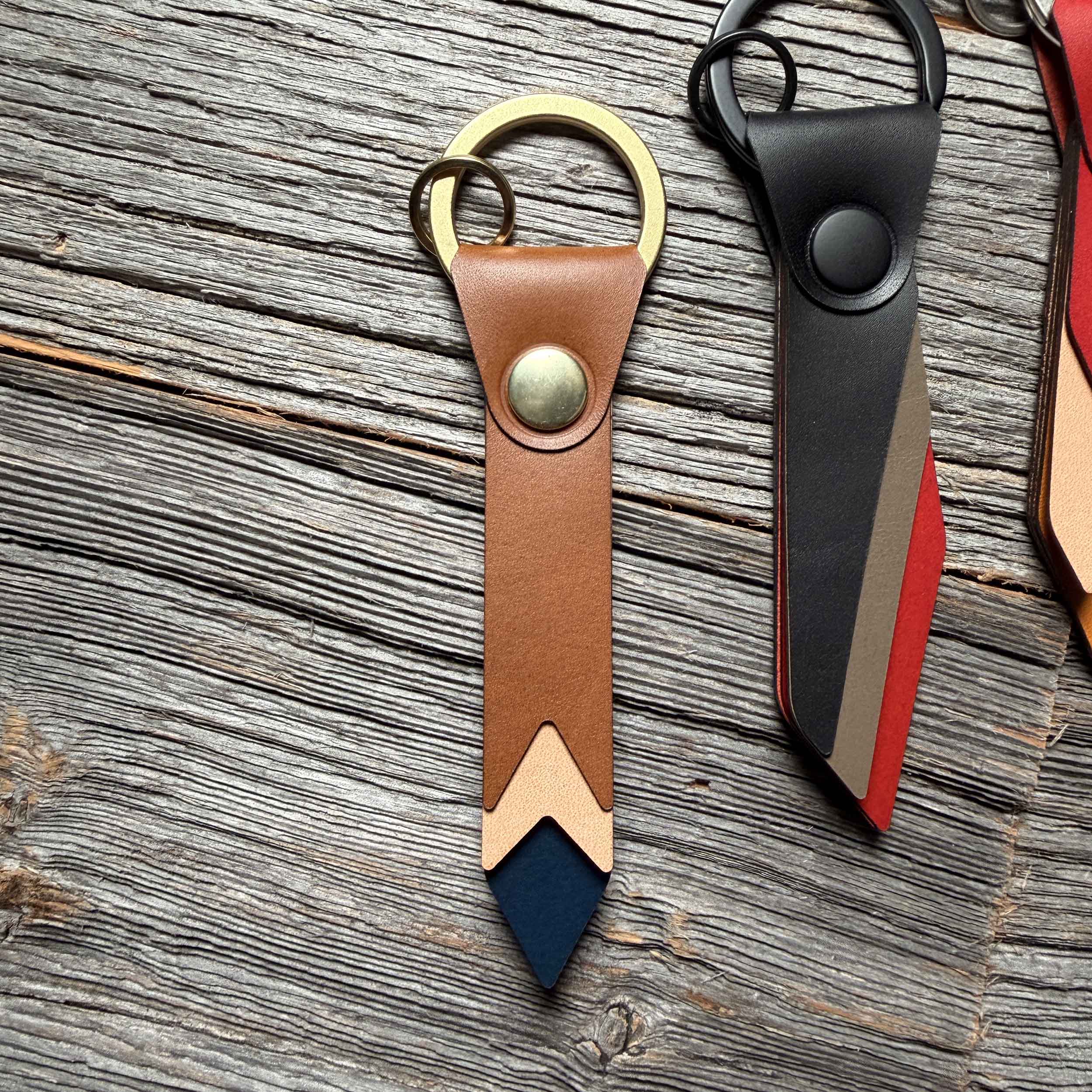 Horizon leather keychain styled on weathered wood beside other Keyway full-grain veg-tan colorways