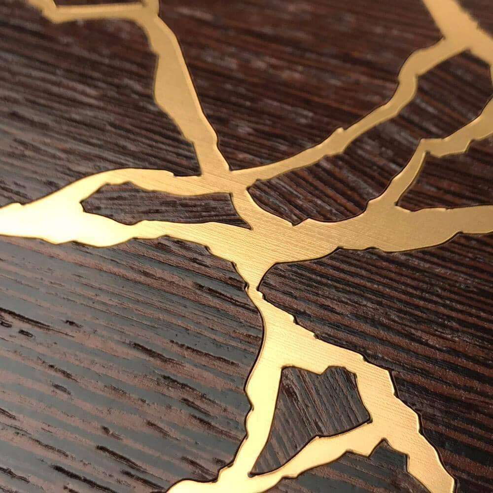Zoomed in detail shot of the Restore Wenge and gold wood phone case by Keyway