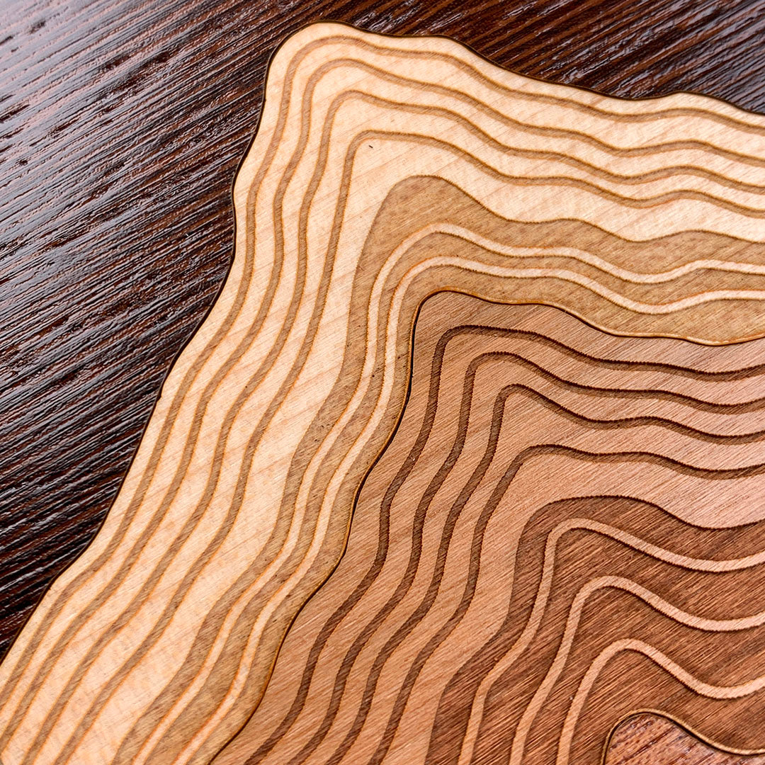 Zoomed in detailed shot of the Summit case featuring a tight pattern of Walnut, Wenge, Maple, and Padauk wood