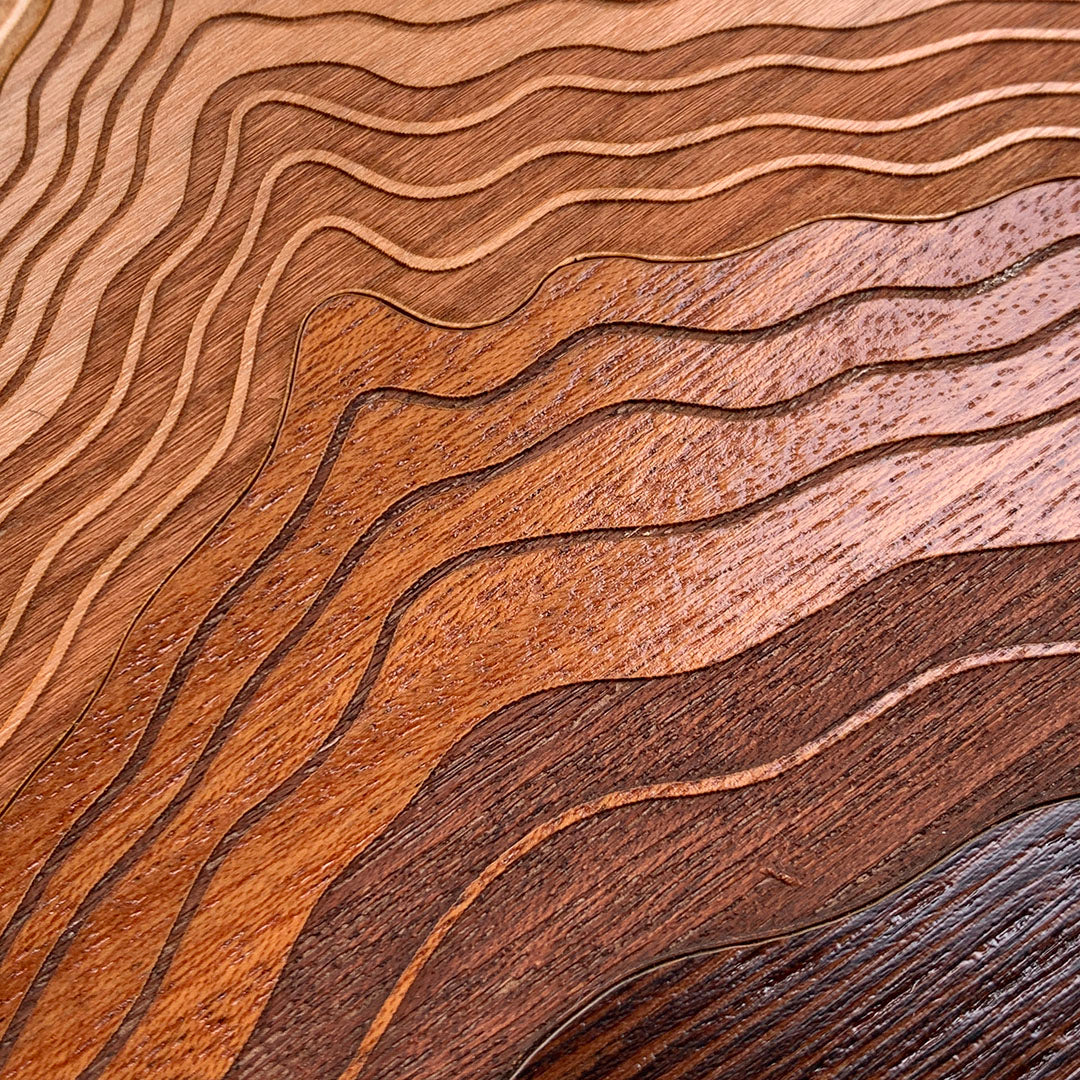 Head-on zoomed in detailed shot of the Summit case featuring a tight pattern of Walnut, Wenge, Maple, and Padauk wood