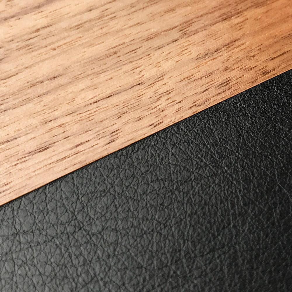 Zoomed in detail shot of the Walnut Rift division between Walnut wood and vegetable-tanned charcoal leather phone case by Keyway