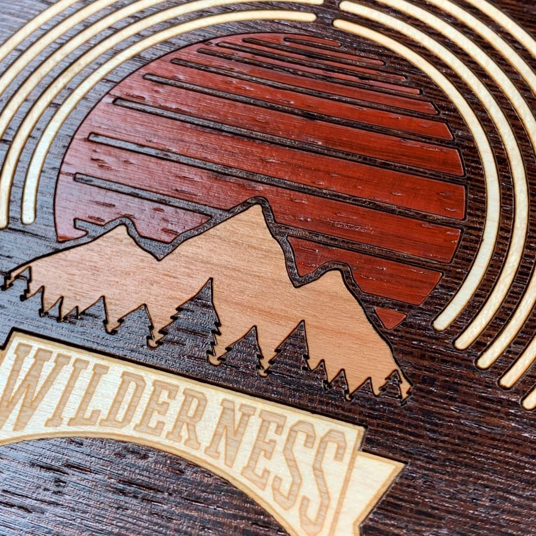 Zoomed in detailed shot of the Wilderness Case featuring a Maple, Padauk, and Cherry Sunset inlay on a Wenge Wood backer