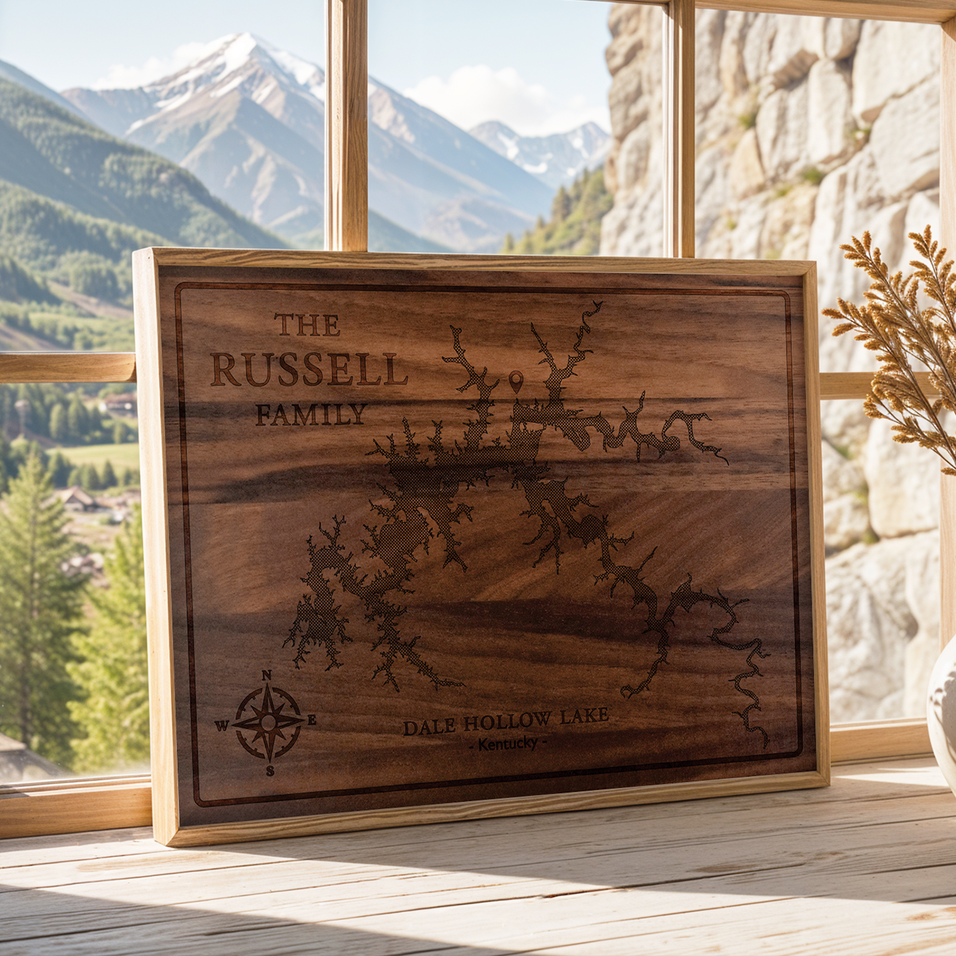 Framed walnut wood map of Dale Hollow Lake, Kentucky, personalized for the Russell family and displayed on a sunlit windowsill with mountain views. A rustic, handcrafted décor piece perfect for cabins, lake homes, or nature lovers.