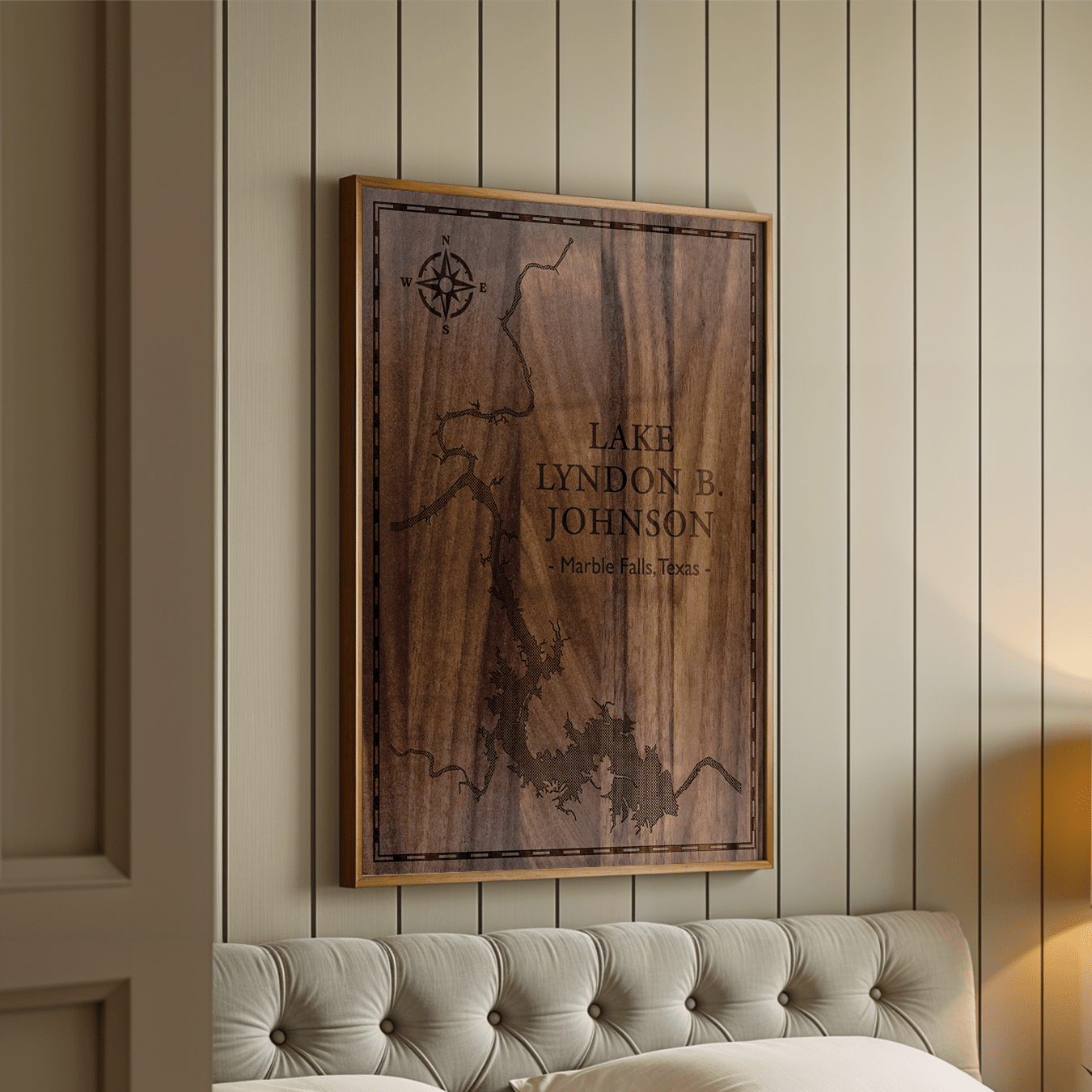 Framed walnut wood map of Lake Lyndon B. Johnson, Marble Falls, Texas, featured in an elegant bedroom with tufted headboard and vertical panel walls. The deep laser engraving adds a touch of luxury and warmth to upscale interior décor.