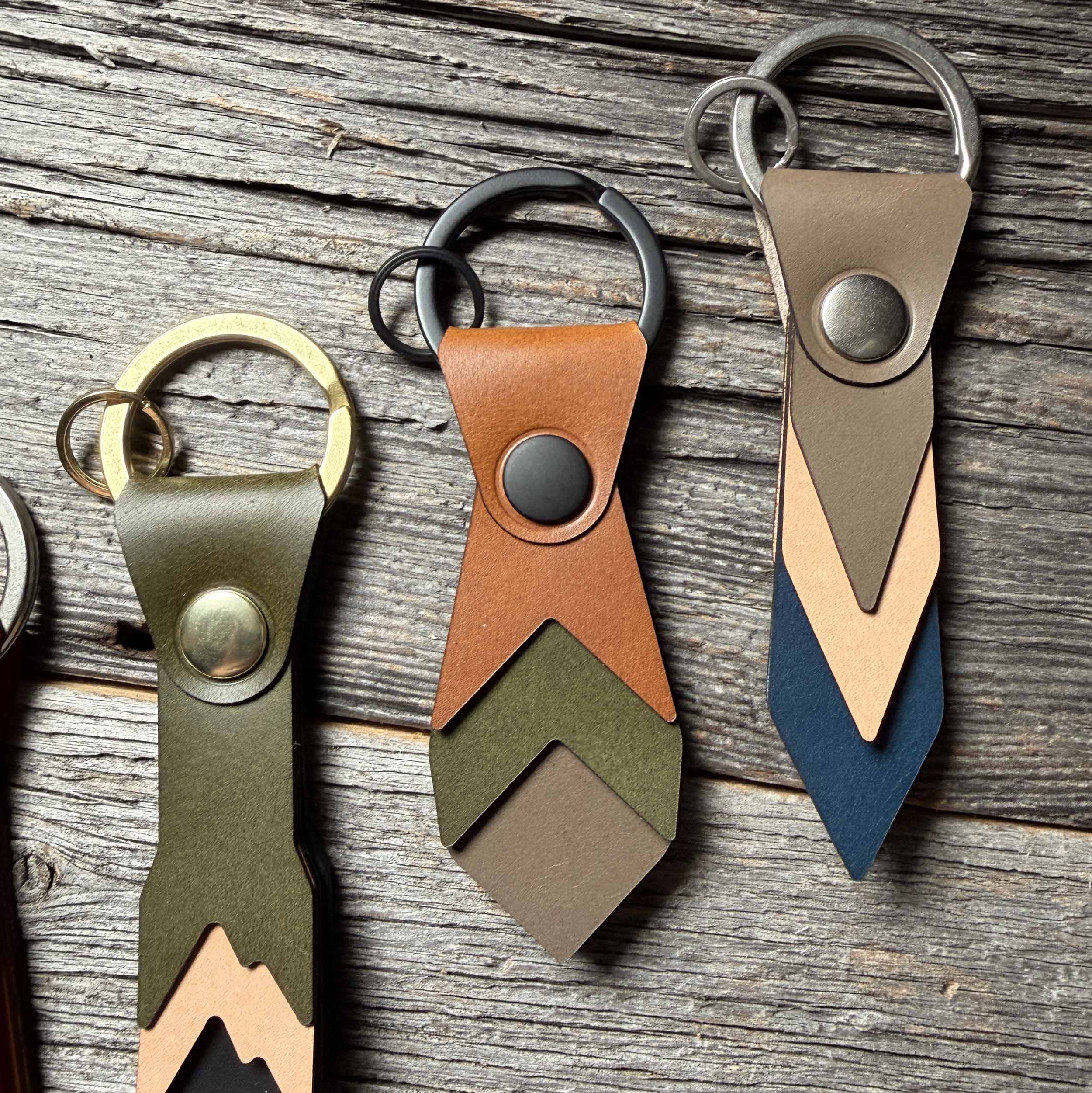 Bramble leather keychain styled on weathered wood beside other Keyway full-grain veg-tan colorways