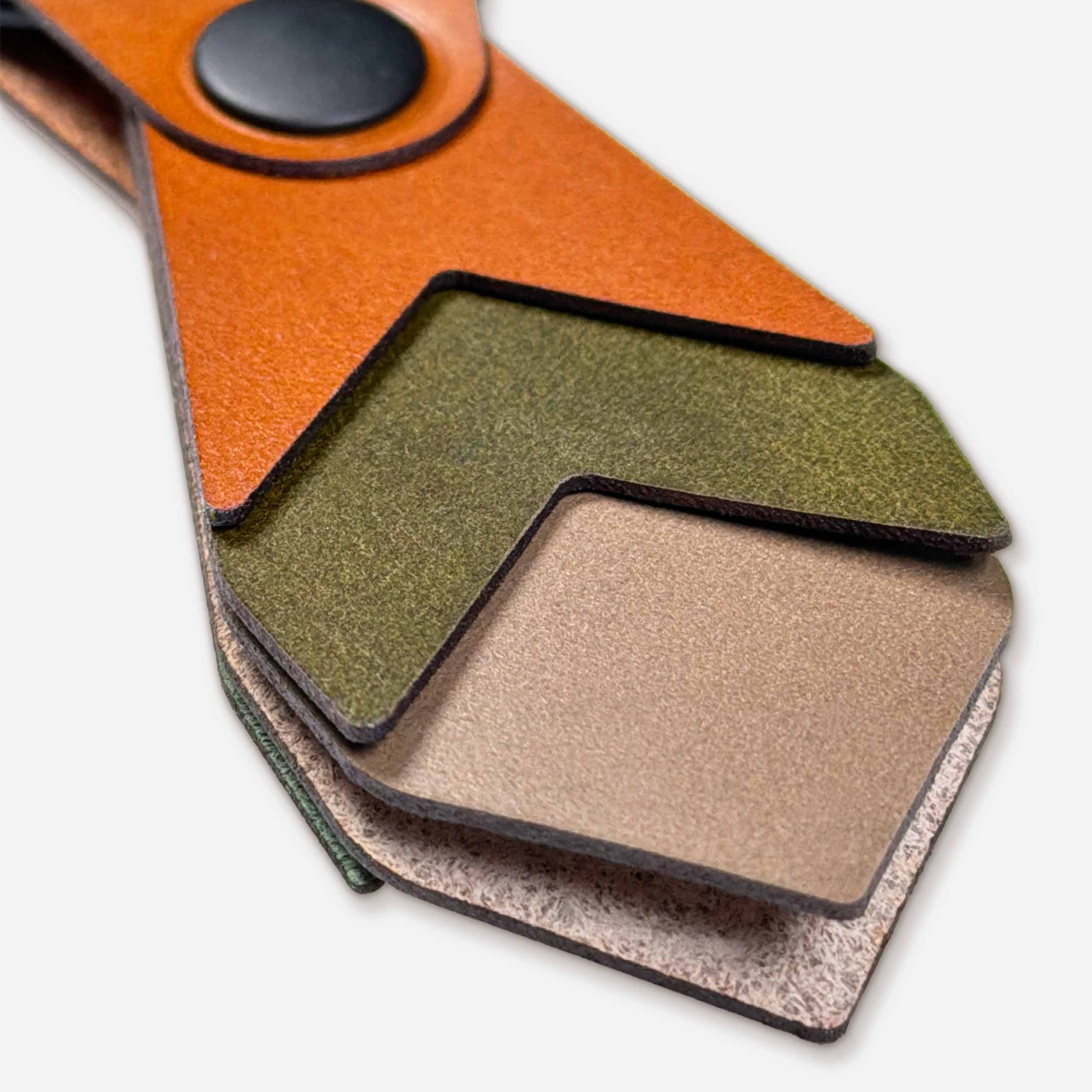 Close-up of Bramble leather keychain showing layered Italian full-grain veg-tan in cognac, olive, and taupe