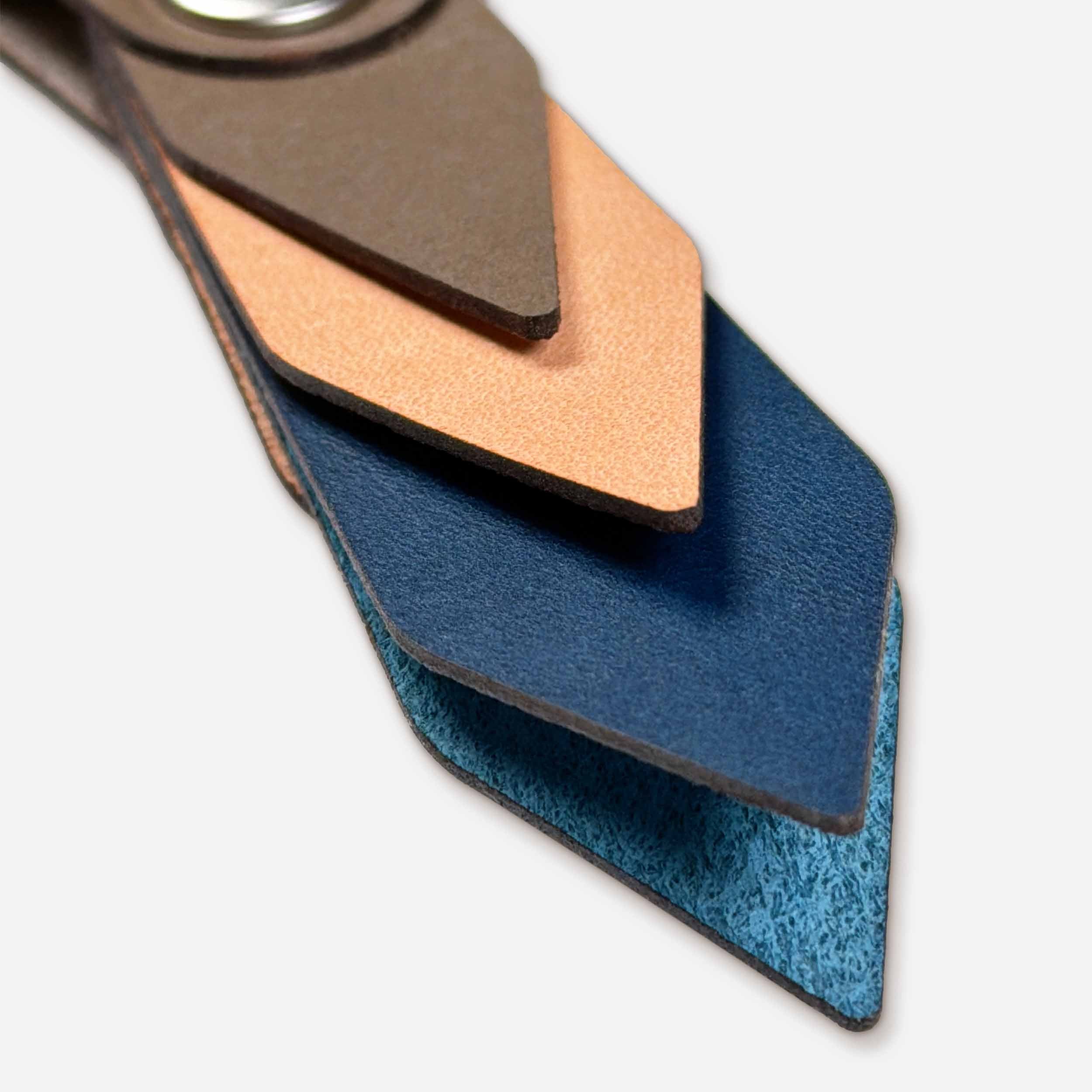 Close-up of Driftwood leather keychain showing layered Italian full-grain veg-tan in taupe, natural, and midnight