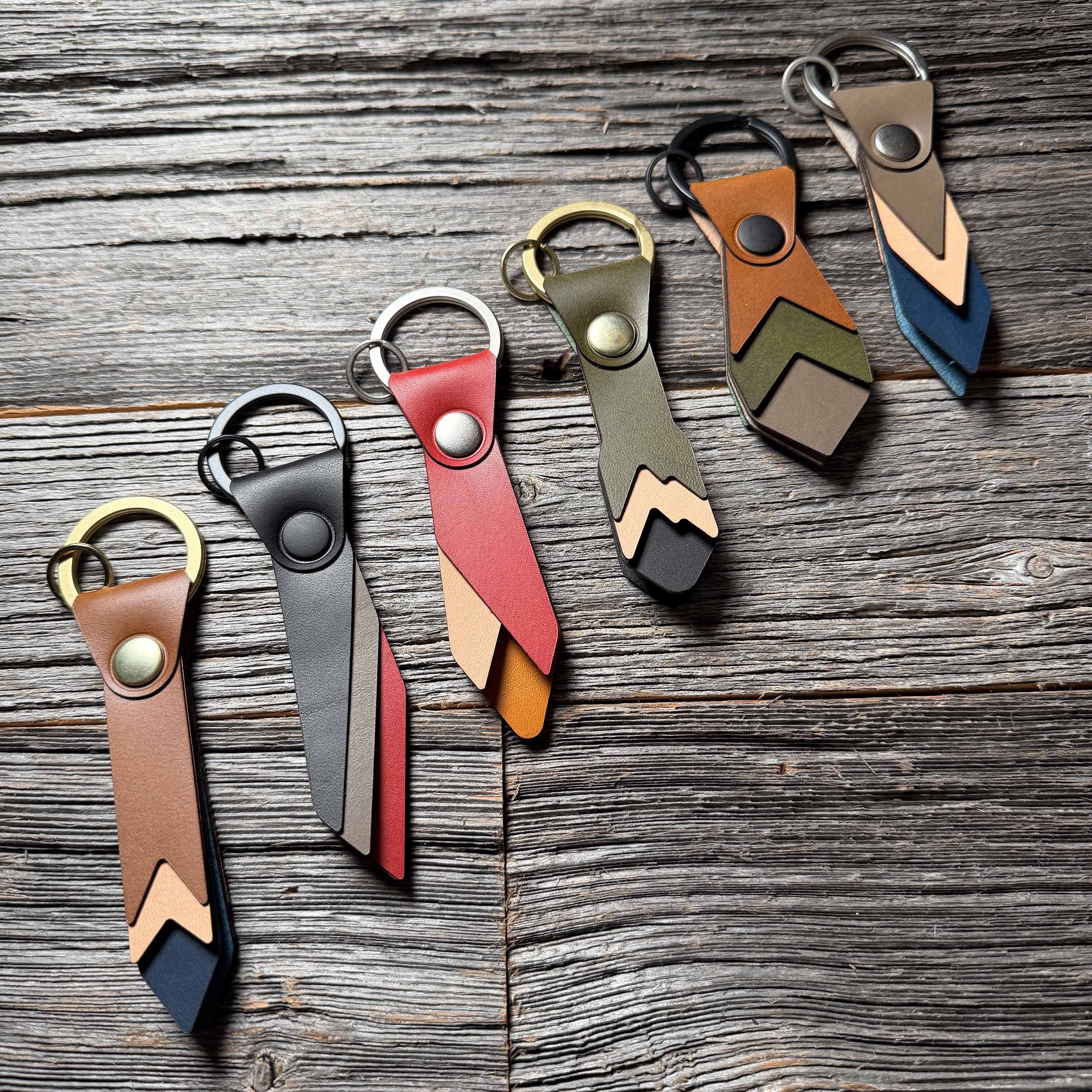 Driftwood with full Keyway leather keychain collection on weathered wood — six handmade colorways