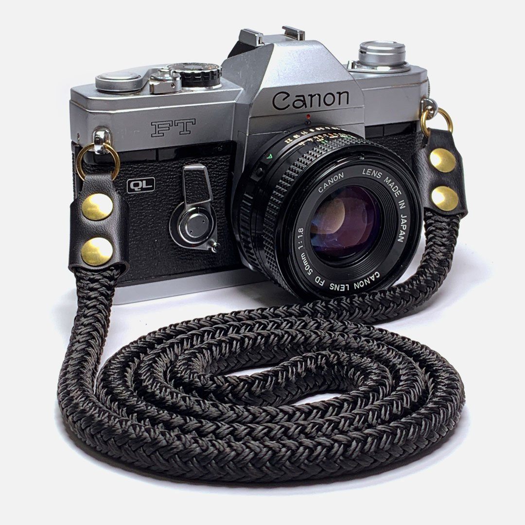 Camera Neck Strap. Black Leather, Brass and Black Nylon. Designed to hang below the chest.