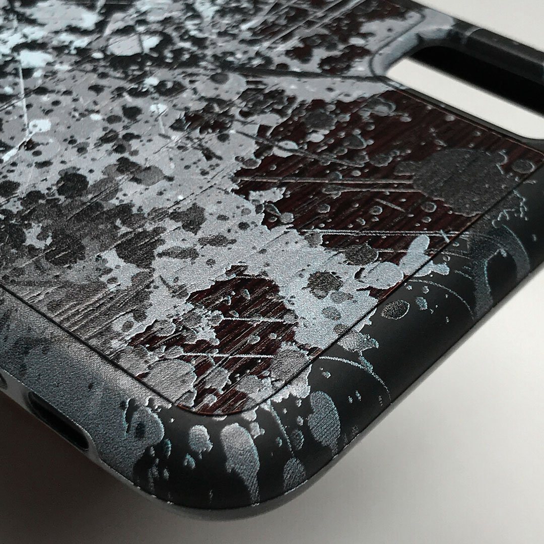 Zoomed in detailed shot of the aggressive, monochromatic splatter pattern overprintedprinted Wenge Wood iPhone X Case by Keyway Designs